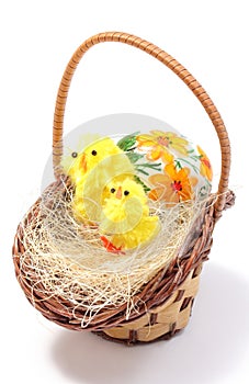 Easter chickens in wicker basket and painted egg