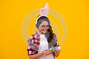 Easter child holidays concept. Happy smiling little teenage girl with bunny ears holding painted easter eggs. Happy