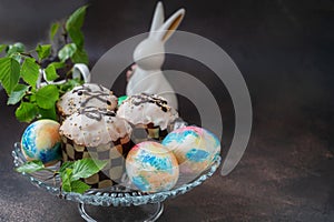 Easter chocolate cupcakes with colored eggs. Easter cupcakes with vanilla frosting, candy eggs and sprinkles, holiday