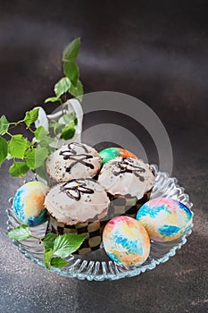 Easter chocolate cupcakes with colored eggs. Easter cupcakes with vanilla frosting, candy eggs and sprinkles, holiday