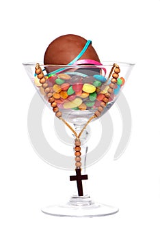 Easter chocolate egg , sweets and cross in a glass