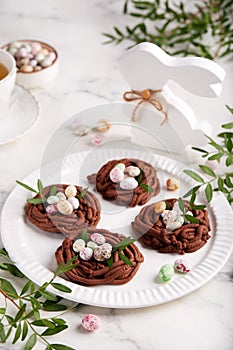 Easter chocolate shortbread cookies in a shape of nest filled with colorful egg candies.