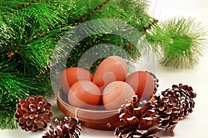 Easter Close-Up of Eggs in a Basket with Several Pinecones and green spruce on white background