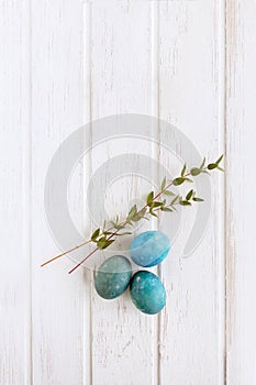 Easter colored eggs on a light wooden background. Copyspace