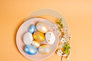 Easter colored eggs on a plate on a beige background