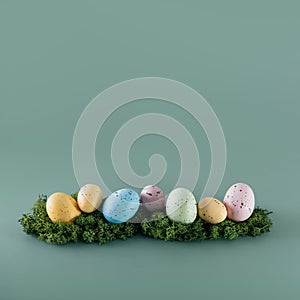 Easter colored eggs in a row laying on the moss on the green background. Happy Easter holiday. Muted colors. Square card