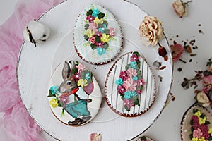 Easter colored gingerbread in the shape of an egg with a rabbit and flowers drawn on them