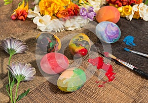Easter colorful eggs with spring flowers and two painter's brushes.