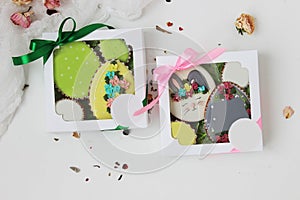 Easter colorful gingerbread in the shape of an egg with a rabbit drawn on them and flowers in a gift box