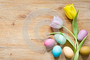 Easter colorful simple eggs and spring tulips on wooden background