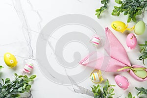 Easter composition with Bunny ears, colored eggs and green plants.
