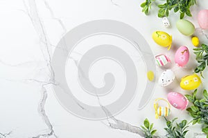 Easter composition with Bunny ears, colored eggs and green plants.