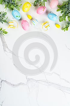 Easter composition with Bunny ears, colored eggs and green plants.