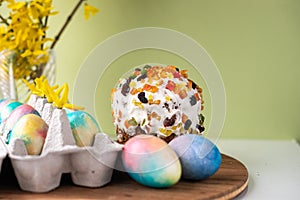 Easter composition with colorful eggs, wooden stand and spring flowers on a yellow background. Easter cake Banner. copy