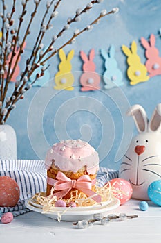 Easter composition with Easter cake and eggs on wooden table against blue background