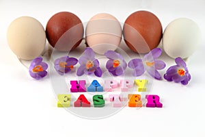 Easter composition with easter eggs, spring flower Saffron crocus and colorful text Happy easter. Greeting card