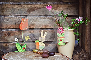 Easter composition of Easter eggs, a wriggle hazel with butterfly and heart and an artificial rabbot with carrot and flower with photo