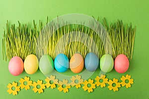 Easter composition of fresh cut grass laid in the face of kerb, multi-colored eggs