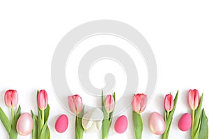 Easter composition with pink tulips, eggs and an Easter bunny isolated on a white background. Copy space, top view, flat lay