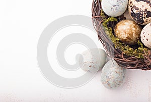 Easter composition with quail eggs in basket on a wooden backround. Top view. Holiday card.