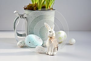 Easter composition with white rabbit and eggs in the sunlight on a white background. The minimal concept