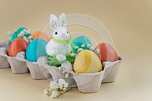 Easter concept with a bunny in nest. Painted easter eggs in egg