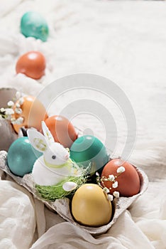 Easter concept with a bunny in nest. Painted easter eggs in egg