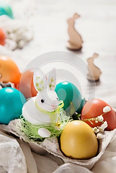 Easter concept with a bunny in nest. Painted easter eggs in egg