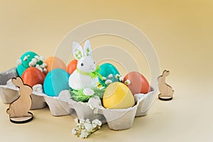 Easter concept with a bunny in nest. Painted easter eggs in egg