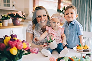 Happy and loving mother and her kids preparing home decoration