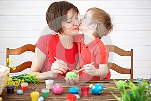 Easter concept. Happy mother and her cute child getting ready for Easter by painting the eggs. Happy family Mom and children son