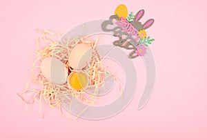 Easter concept on a pink background. Egg on a wooden spoon. A tray of eggs on a white and pink background. eco tray with testicles
