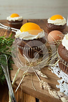 Easter cupcake on wooden background with Peach looks like a fried egg