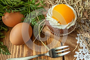 Easter cupcake on wooden background with Peach looks like a fried egg