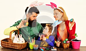 Easter day celebration. Happy family father, mother and little son in bunny ears with painted eggs.