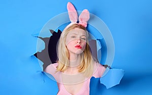 Easter day. Rabbit Girl with bunny ears looking through paper hole. Breaking paper. Sale. Discount.