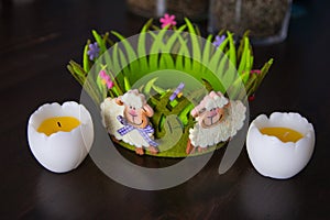 Easter decor with baa-lambs on the green basket and eggs