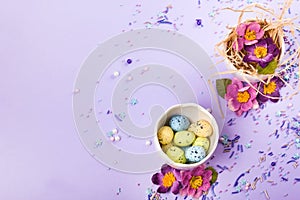 Easter decor in pastel colors. Easter eggs, candy, sweets, flowers and eggshells.