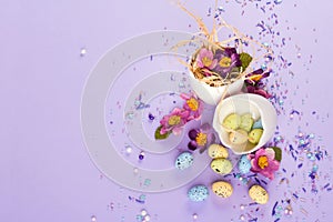 Easter decor in pastel colors. Easter eggs, candy, sweets, flowers and eggshells.