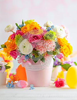 Easter decoration with beautiful spring flowers in vase, Easter eggs and bunny on white wooden table. Easter concept