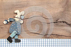 Easter decoration with a blue bunny on a wooden background in sh