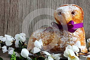 Easter lamb cake with purple ribbon and white florets with leaves