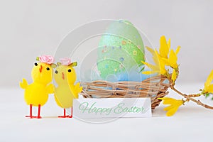 Easter decoration with chicken, green easter egg in basket on white background