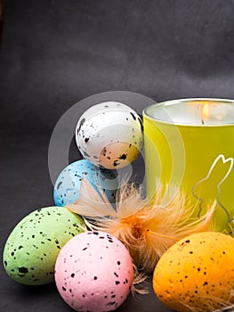 Easter decoration. Colorful eggs and burning candle with rabbit