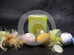 Easter decoration. Colorful eggs and burning candle with rabbit