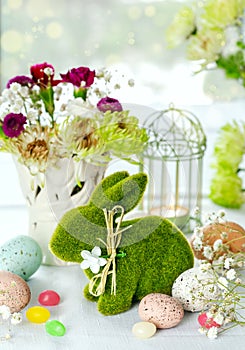 Easter decoration with Easter bunny, eggs and flowers on table
