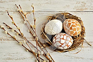 Easter decoration with mosaic eggs and willow twigs on white background.