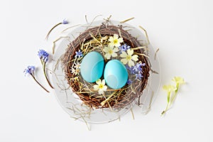 Easter decoration with nest, eggs and spring flowers