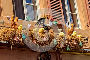 Easter decoration with rooster, hens and chickens in nest on a house