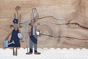 Easter decoration with two rabbits on a wooden background.
